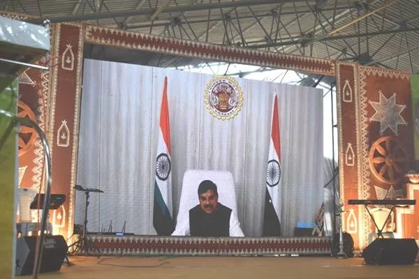 मंच पर लगी बड़ी स्क्रीन पर मुख्यमंत्री डॉ. मोहन यादव वर्चुअल संबोधन देते हुए, दोनों ओर भारतीय ध्वज