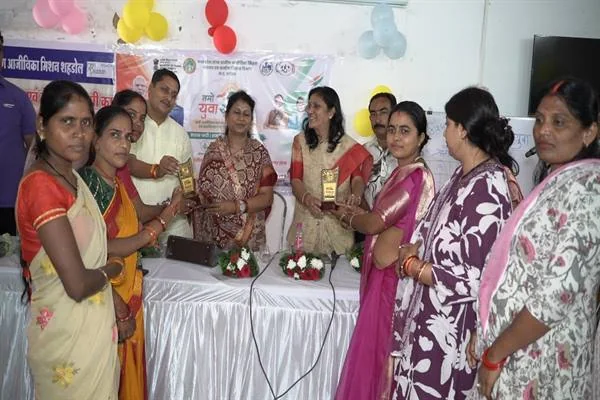सजाए गए सभागार में पुरस्कार हाथ में लिए खड़ी महिलाएं और उनके साथ मौजूद अतिथि