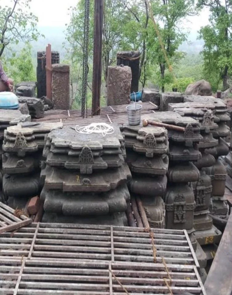जंगल के बीच क्रमांकित प्राचीन पत्थर के मंदिर-अवशेषों के ढेर